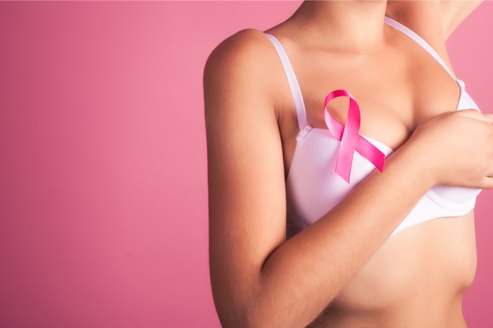 Woman wearing a white bra with pink ribbon on it