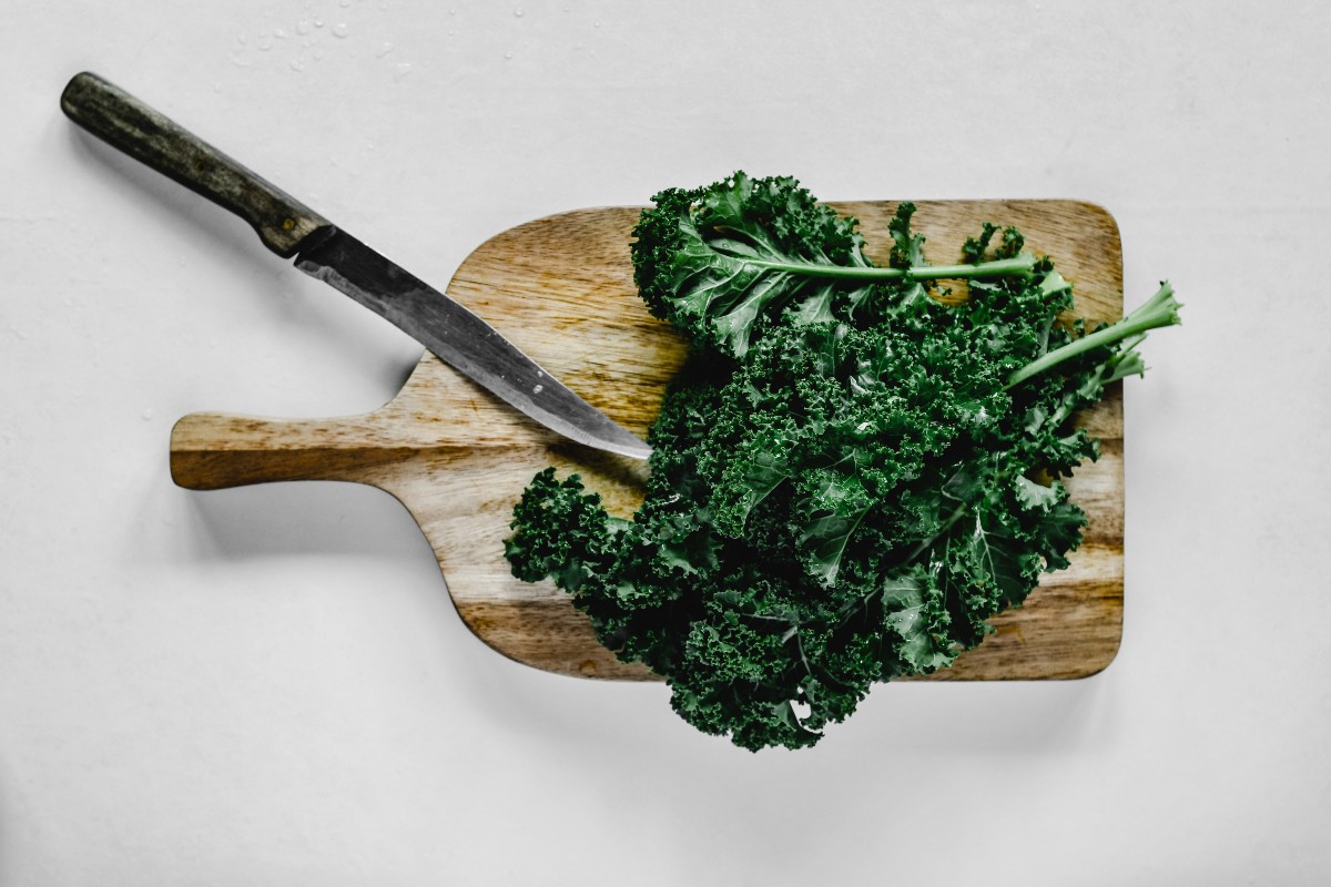 kale on a cutting board with a knife