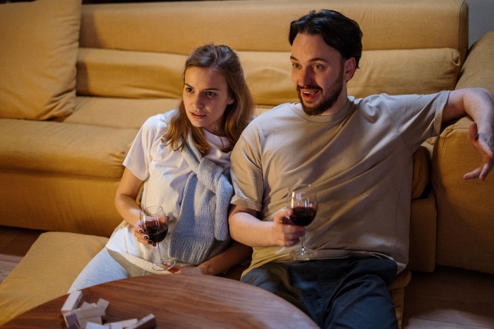 Man and woman watching tv with wine