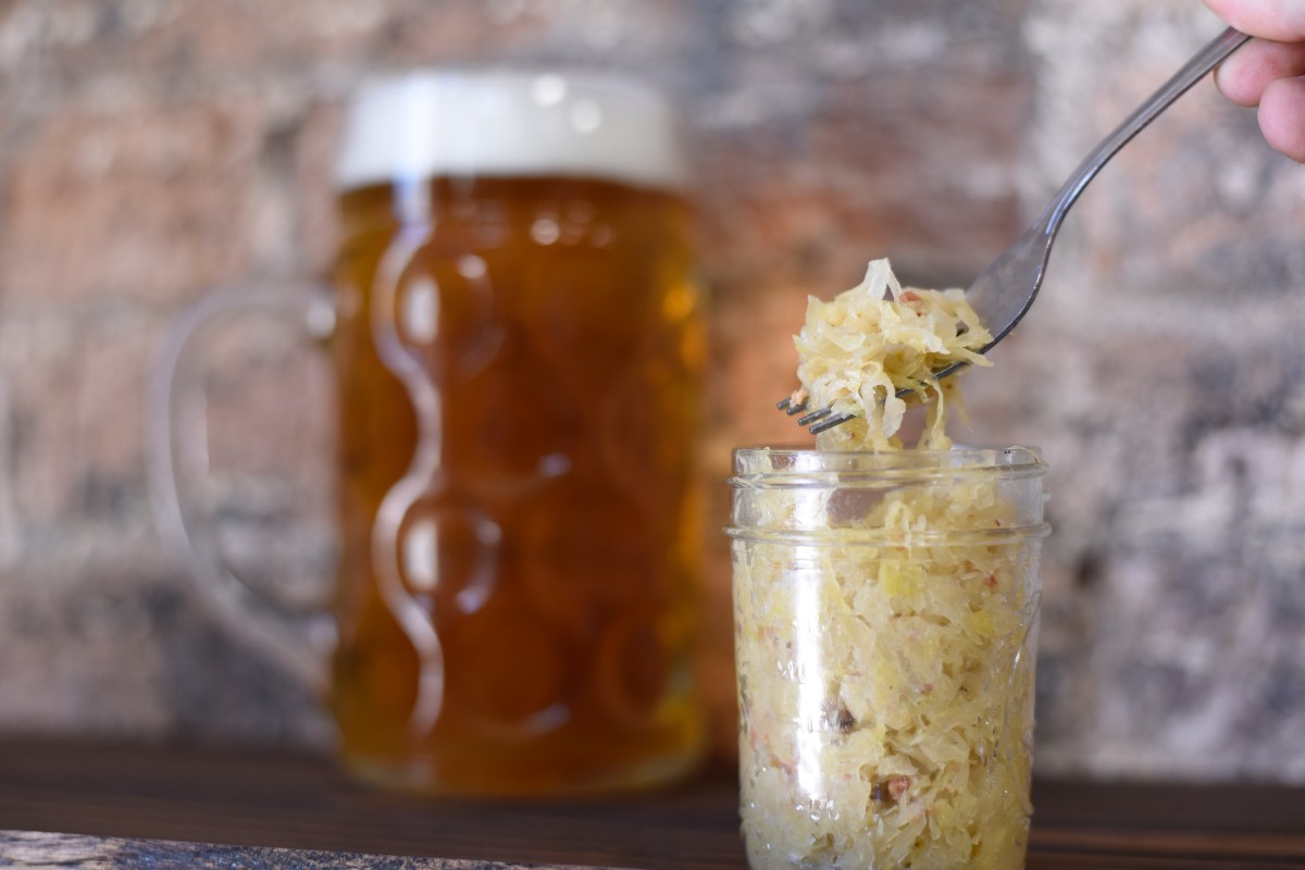 someone spooning sauerkraut out of a mason jar