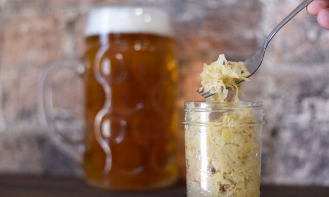 someone spooning sauerkraut out of a mason jar