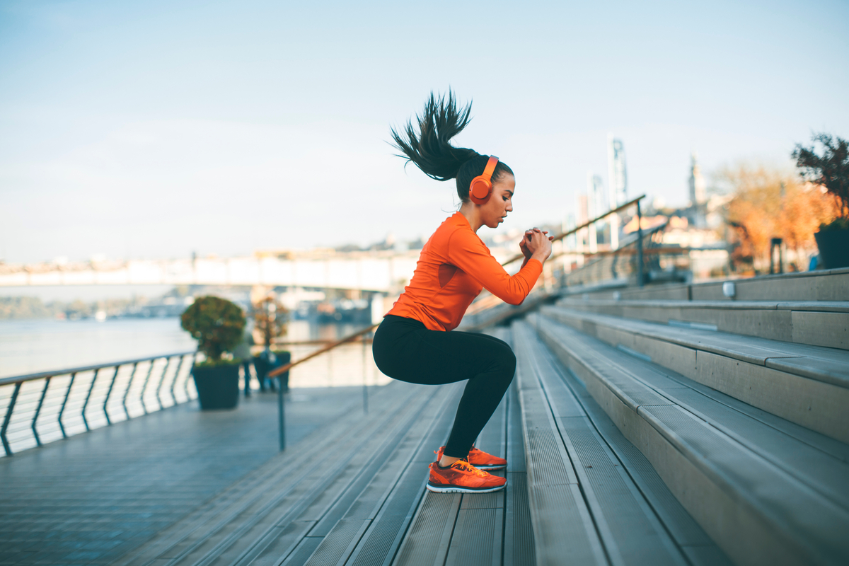 A woman working out jumping on stairs.