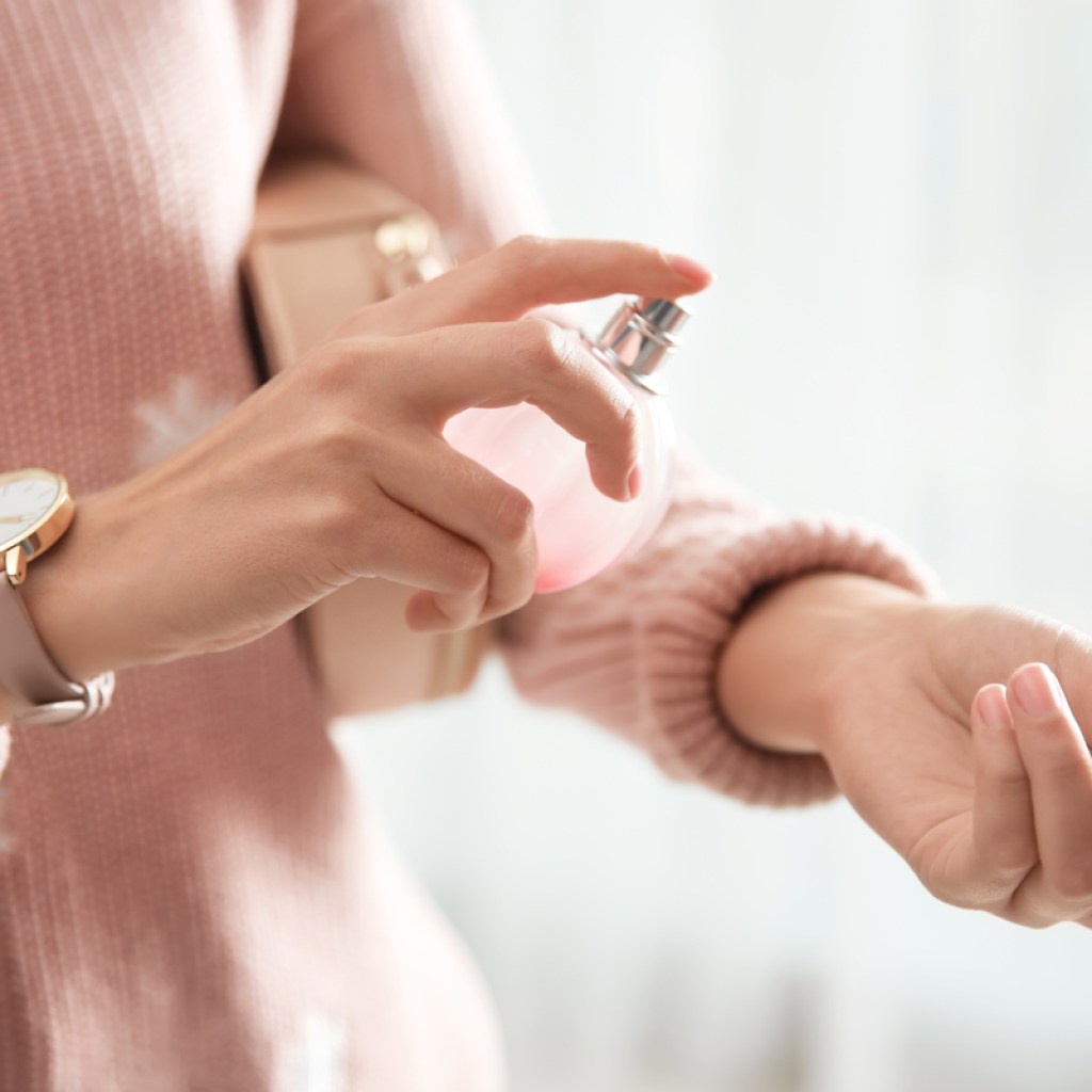A woman applying a fragrance.