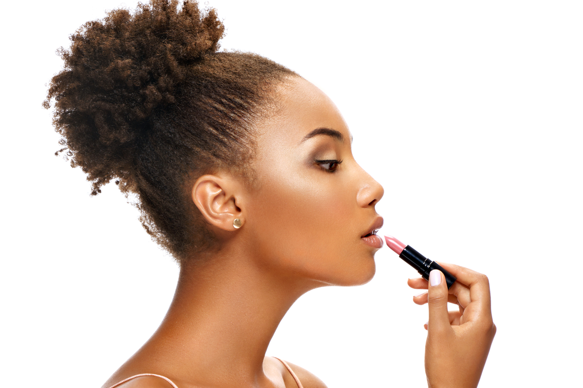 A woman putting on lipstick.