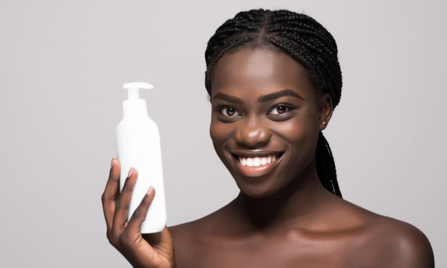A woman holding a lotion bottle.