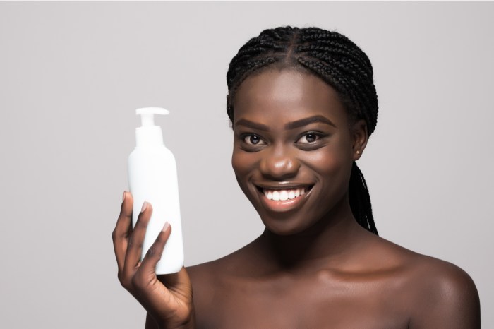 A woman holding a lotion bottle.