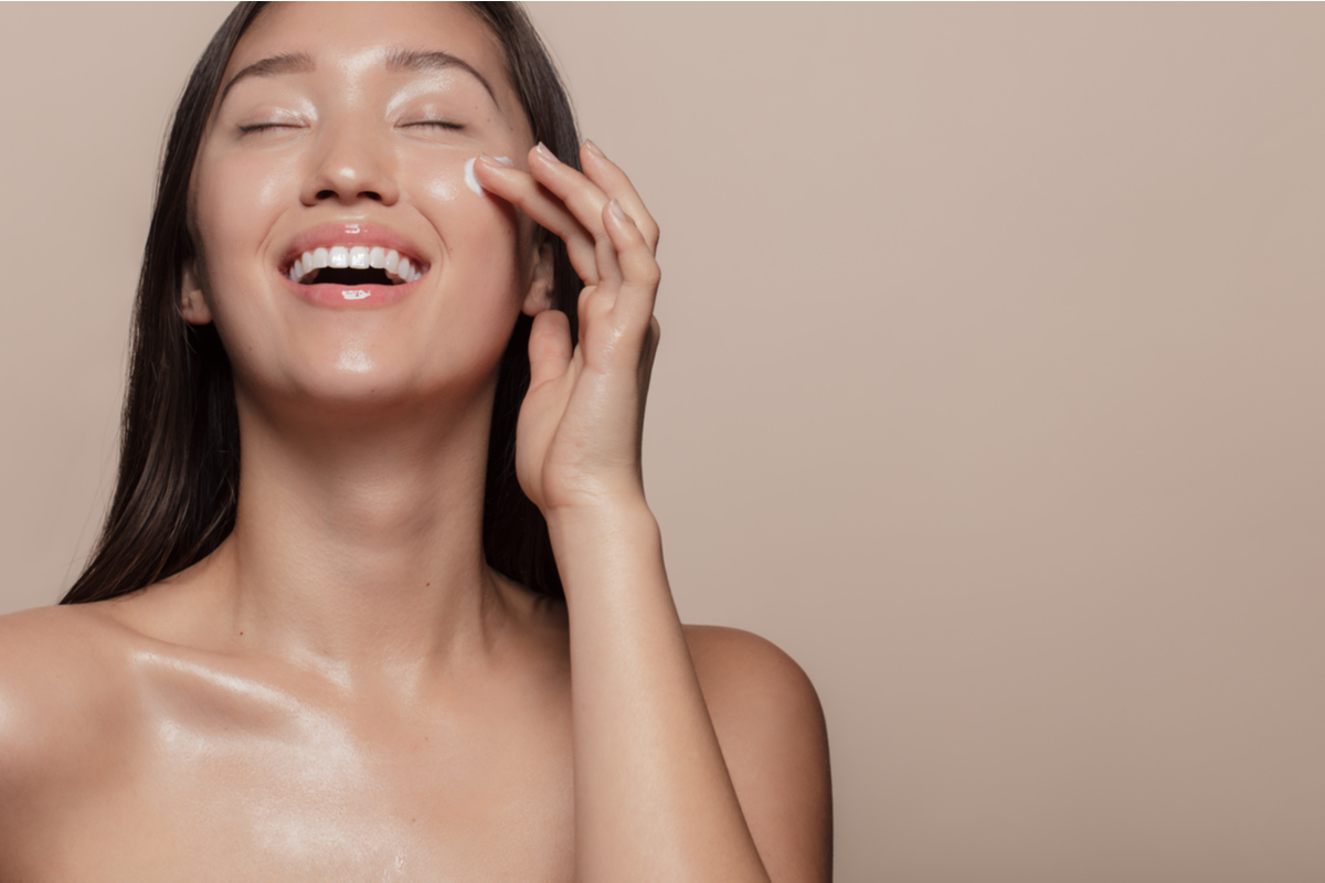 A woman putting on face cream.