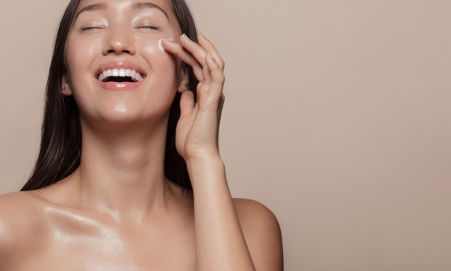 A woman putting on face cream.