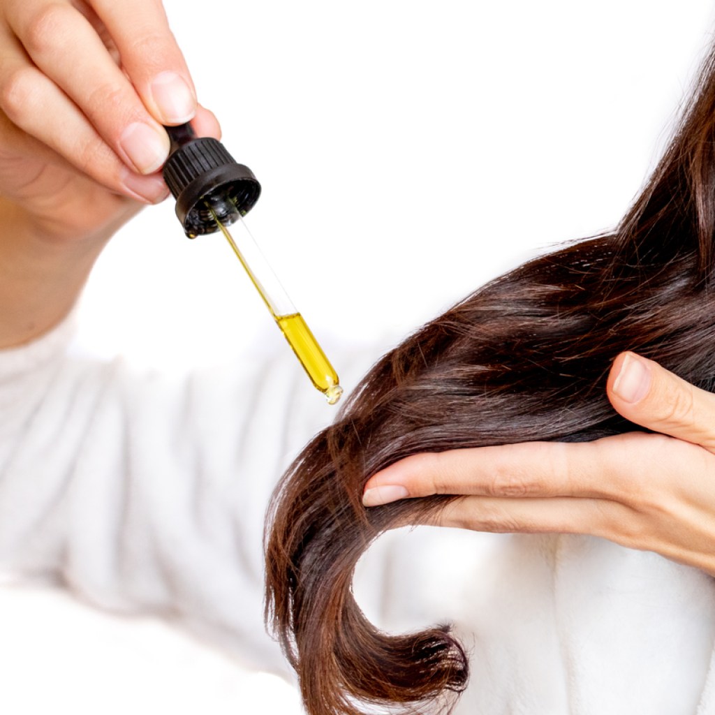 Putting oil in hair.