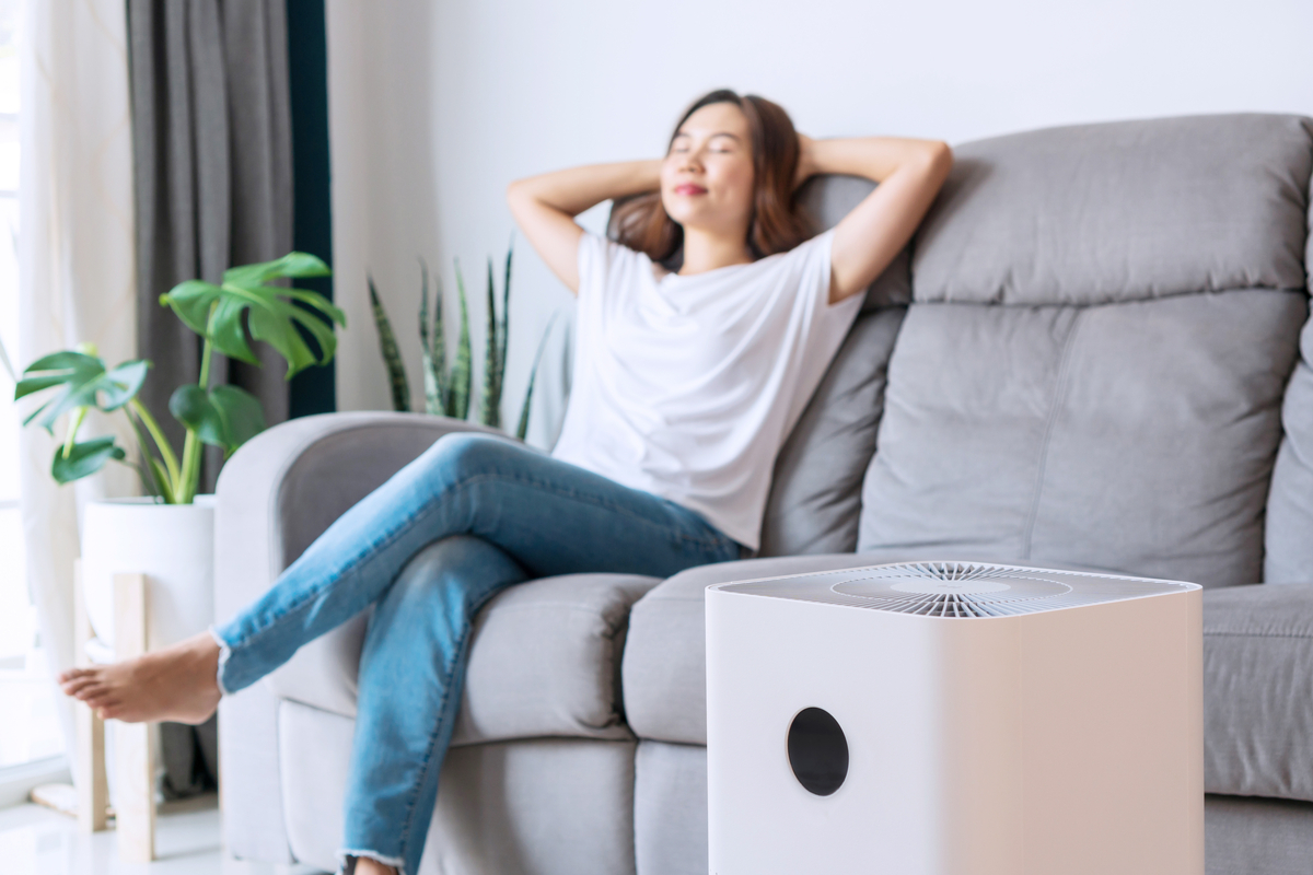A woman enjoying the fresh air from her air purifier.