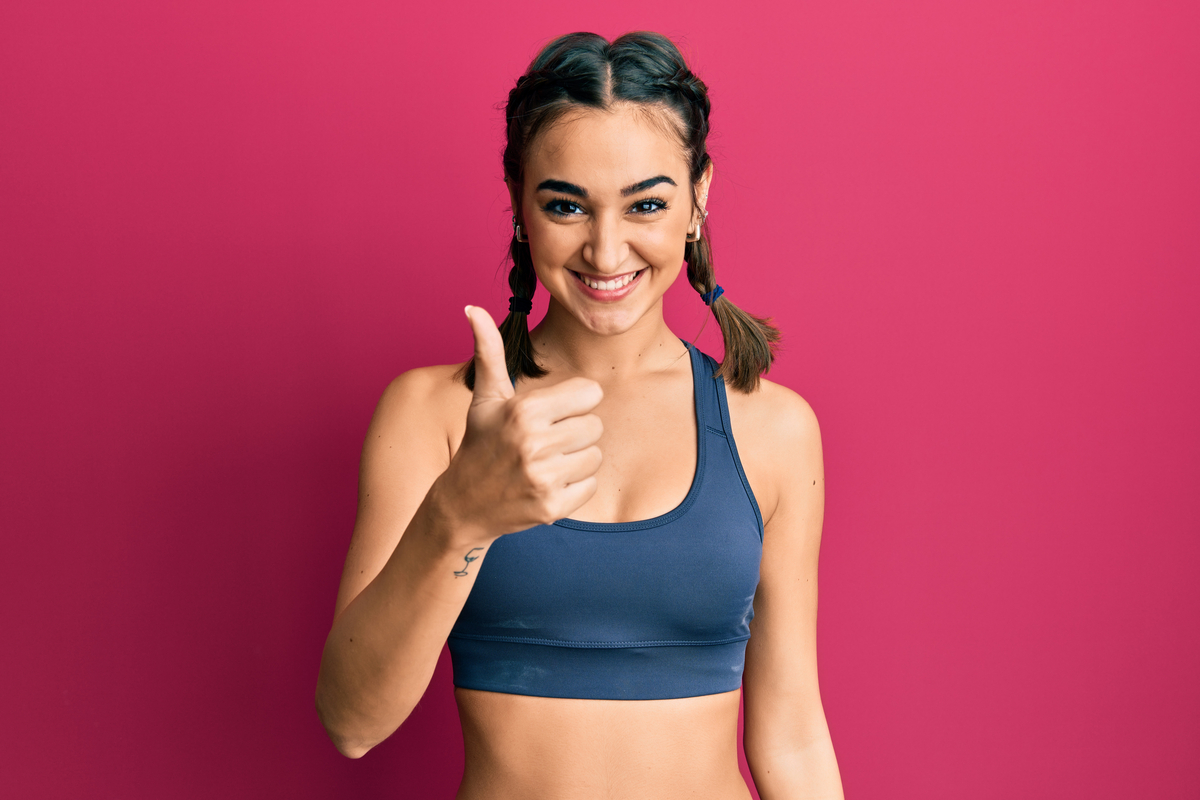A woman ready for her workout with 2 braids in her hair.