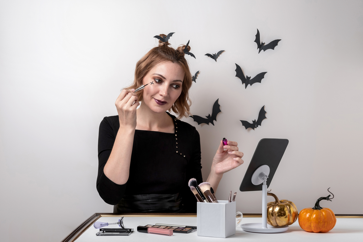 A woman doing her Halloween makeup.