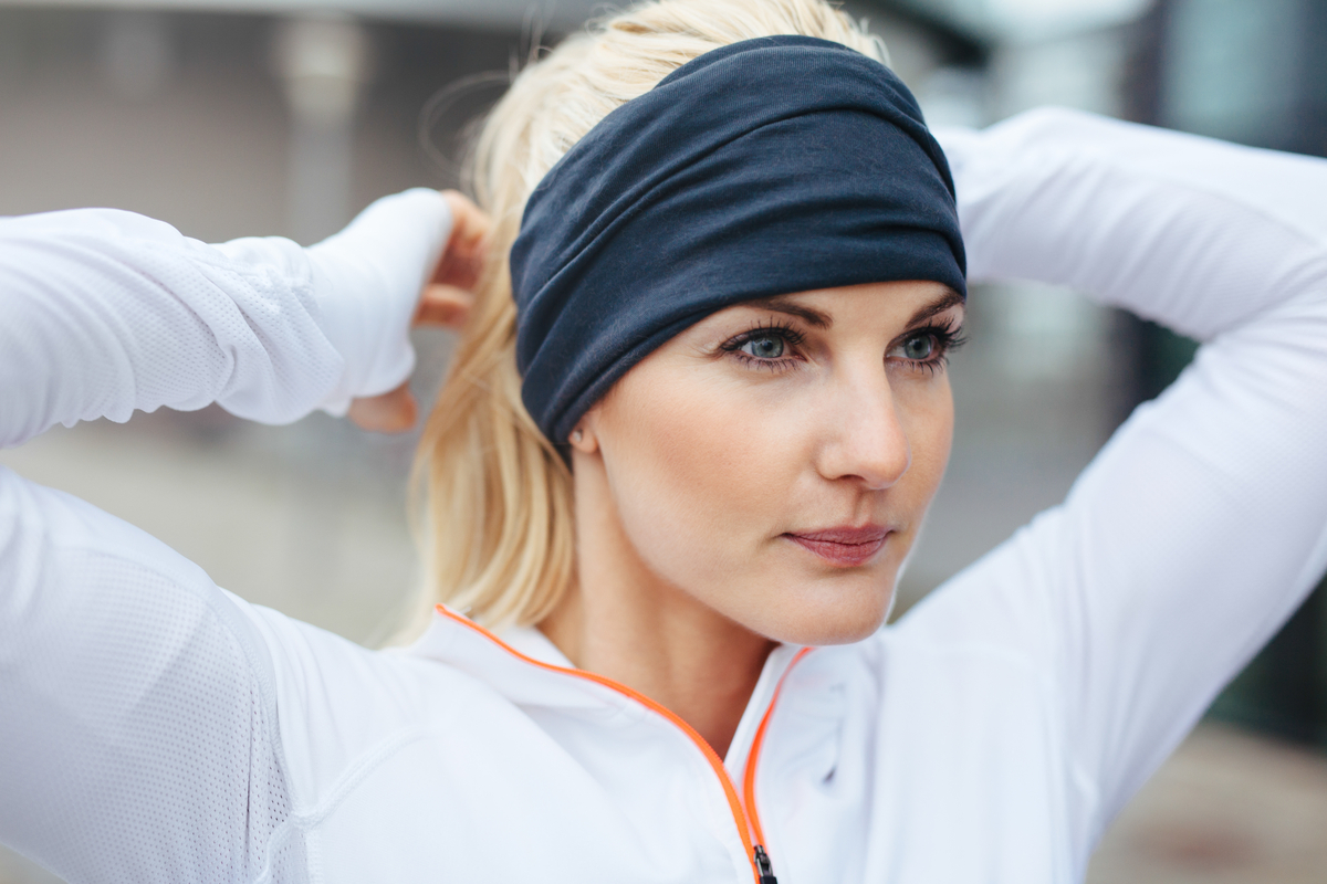 A woman wearing a headband while she works out.