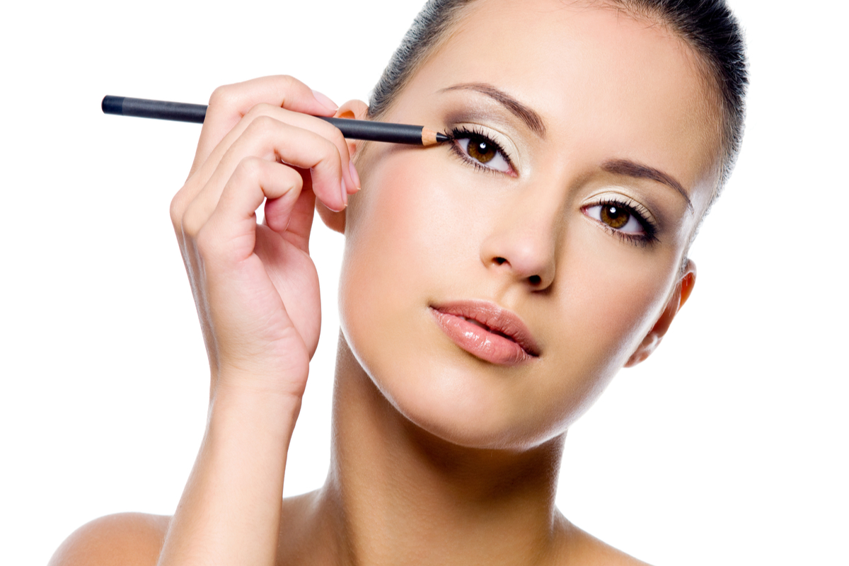 A woman putting on eye makeup.
