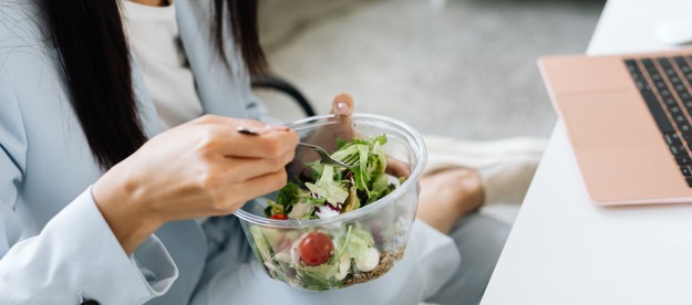 Woman eating a salad at her desk