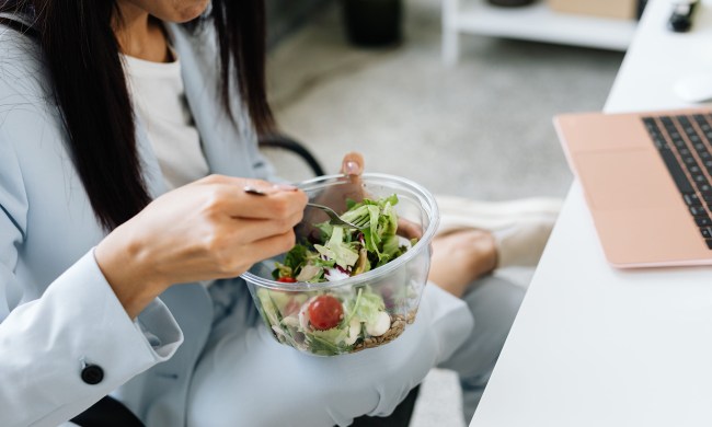 Woman eating a salad at her desk
