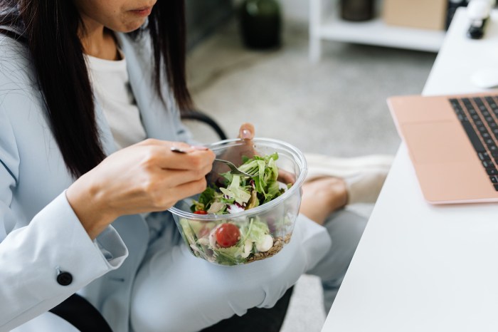 Woman eating a salad at her desk