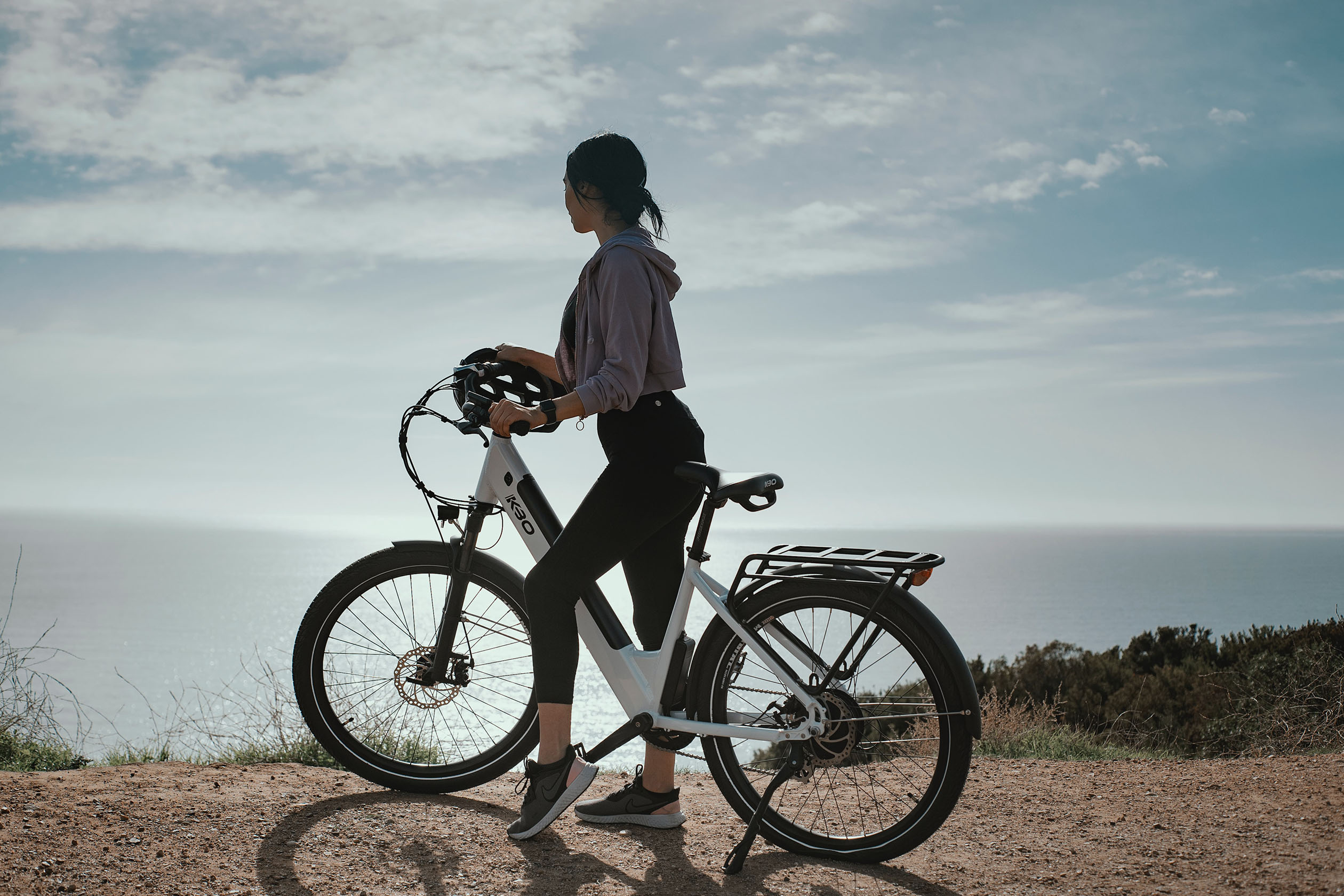 Woman on a bike overlooking the ocean