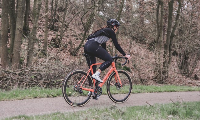 Woman riding an orange bike in the forest