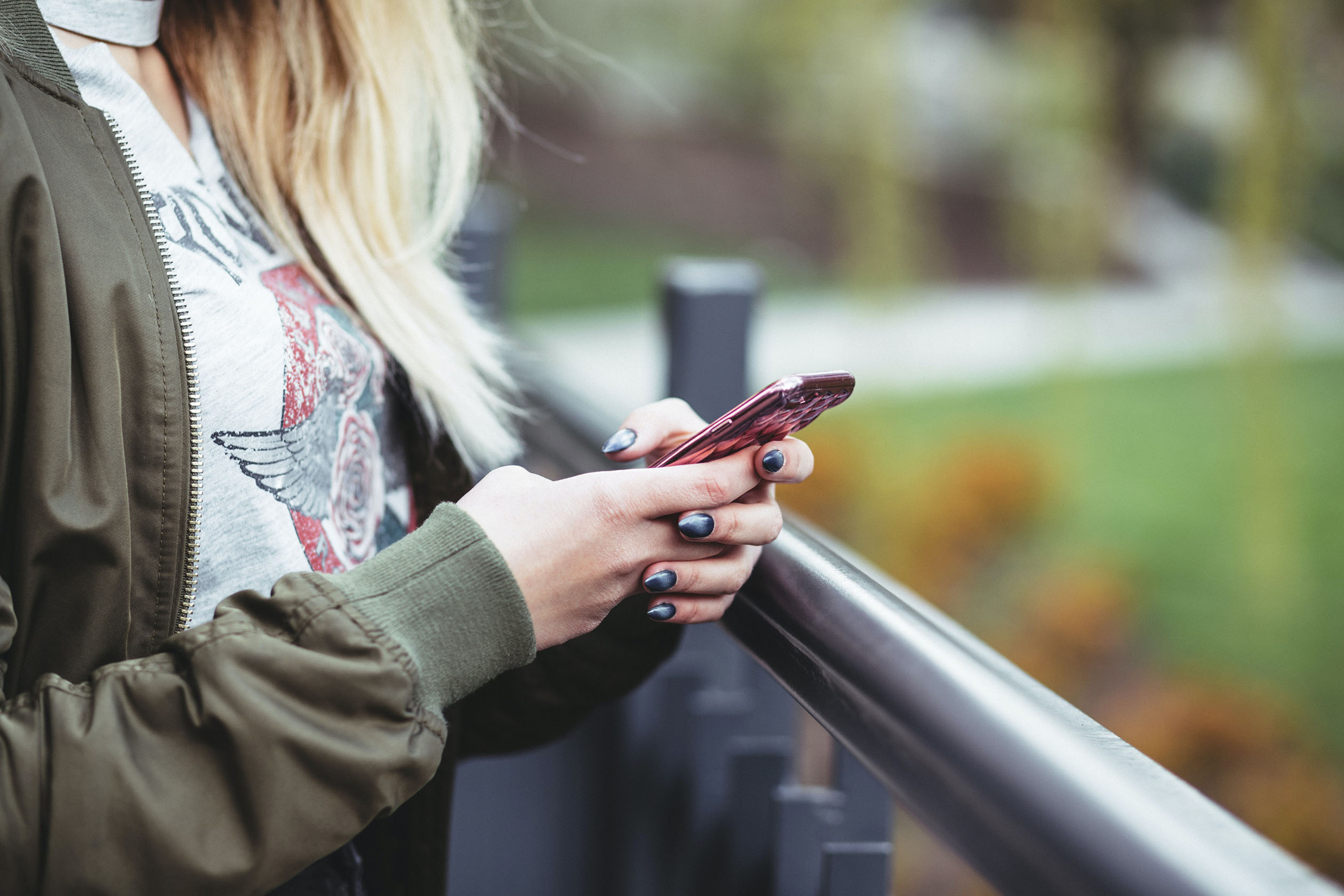 Woman standing outside looking at her phone