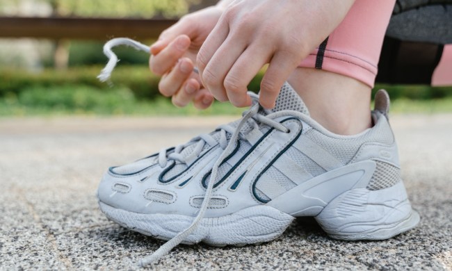 person tying shoelaces while outside
