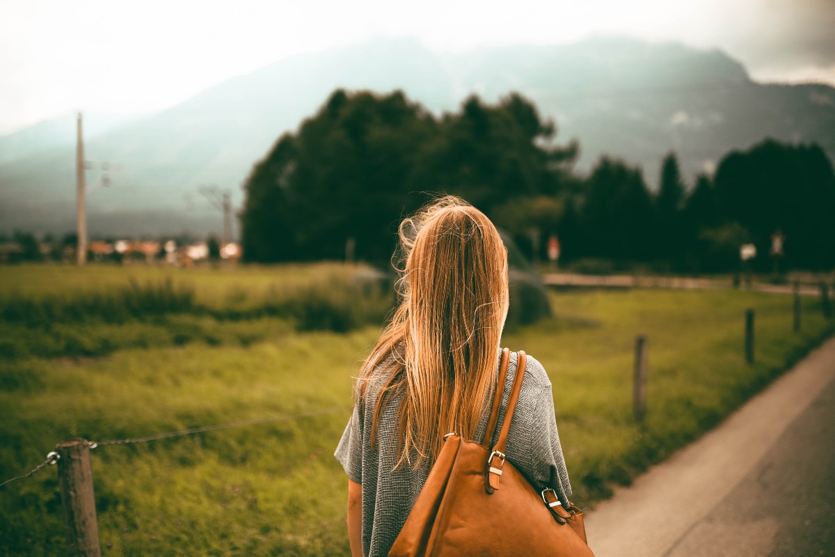 a woman with a brown bag walking outside