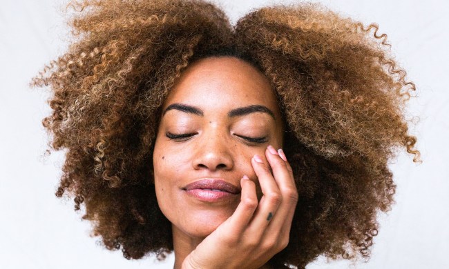Woman with natural hair and her hand on her face