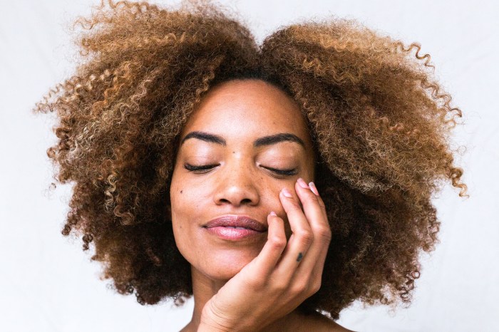 Woman with natural hair and her hand on her face