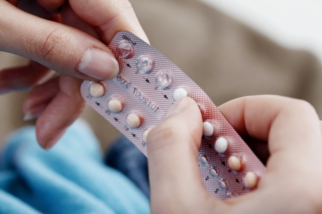 Woman's hands holding birth control pills