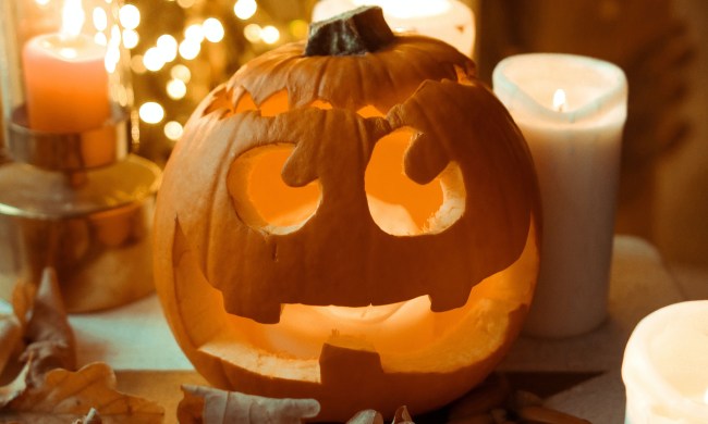 Carved pumpkin, candles, and fall leaves