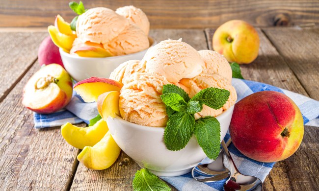 Peach ice cream in bowls with peaches