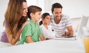 A family gathered around a computer.