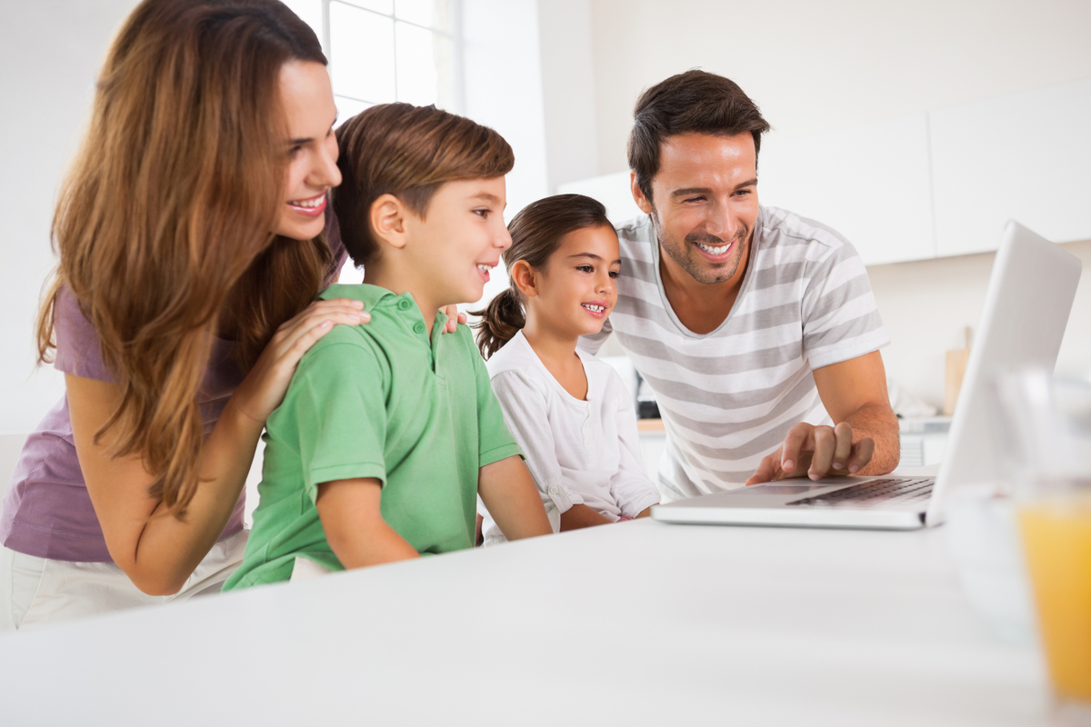 A family gathered around a computer.