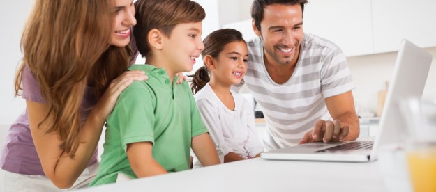 A family gathered around a computer.