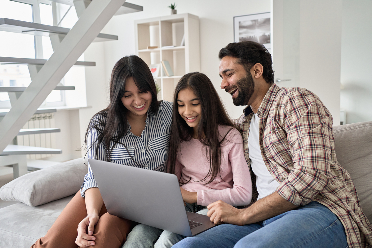 A family having a good time on the computer.