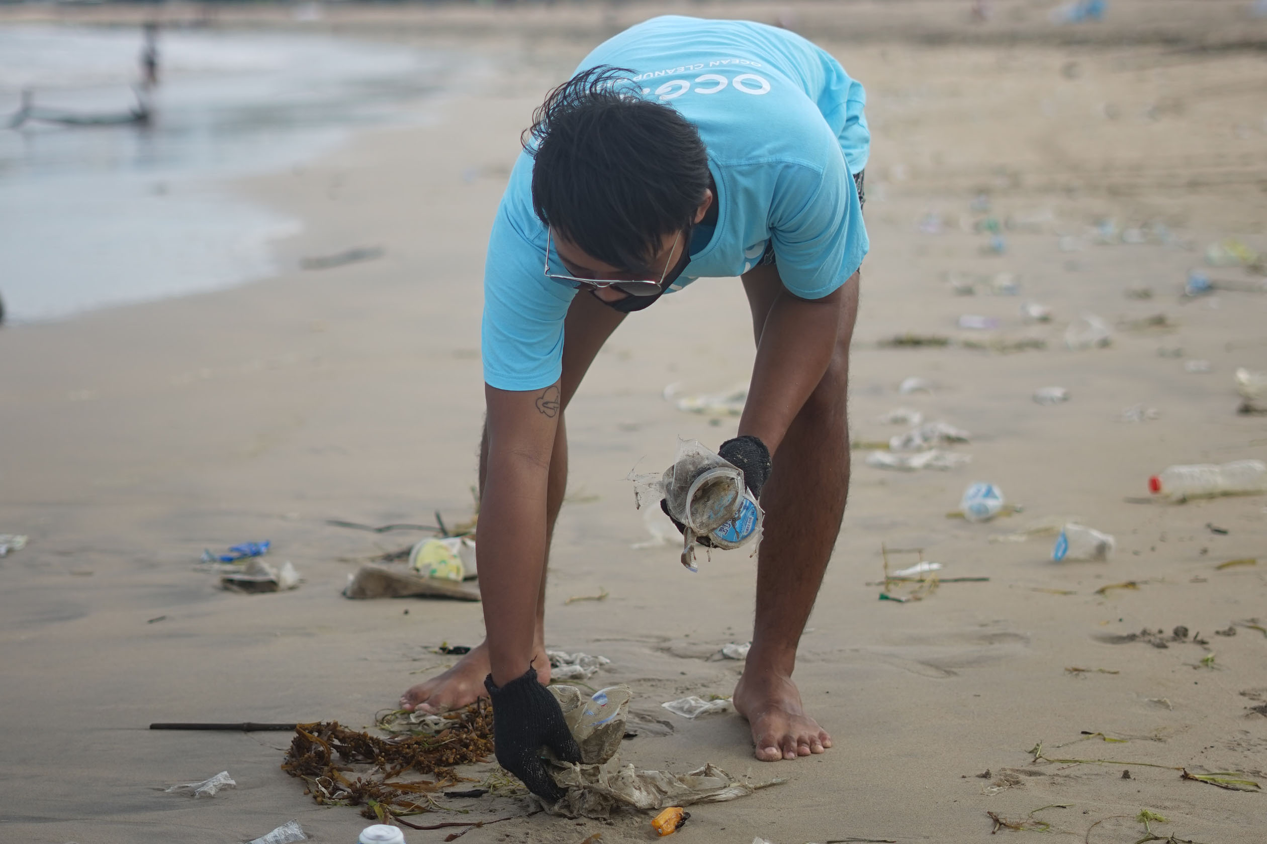 Volunteer picking up trash on the beach