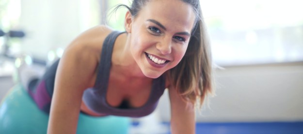 pilates apps woman on ball smiling