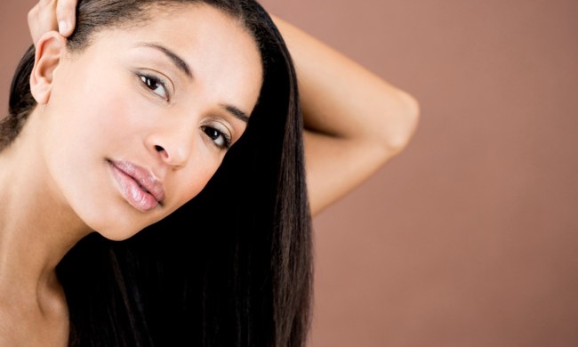 a beauty shot of a woman with straight hair against a brown background