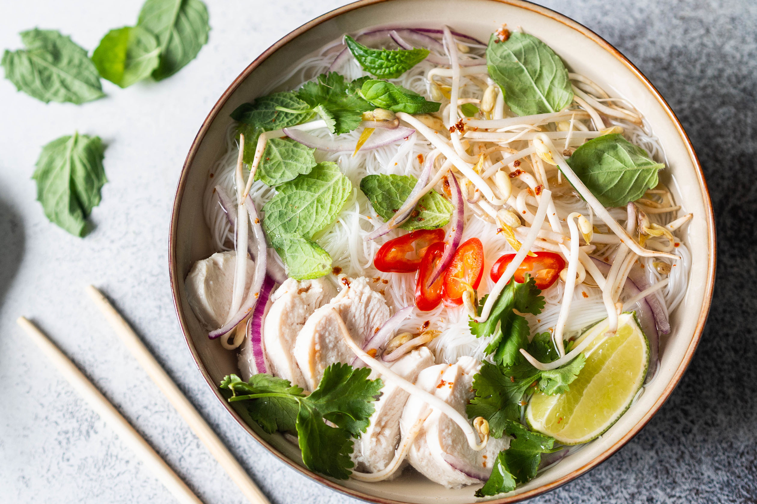 Bowl of chicken pho with chopsticks
