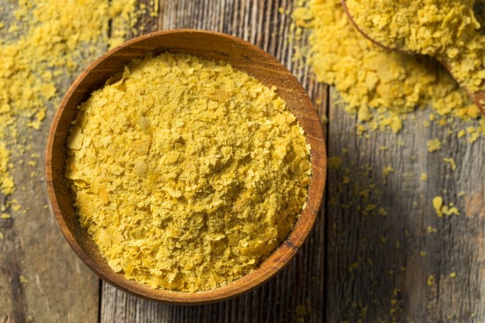 a bowl of nutritional yeast on a wooden table