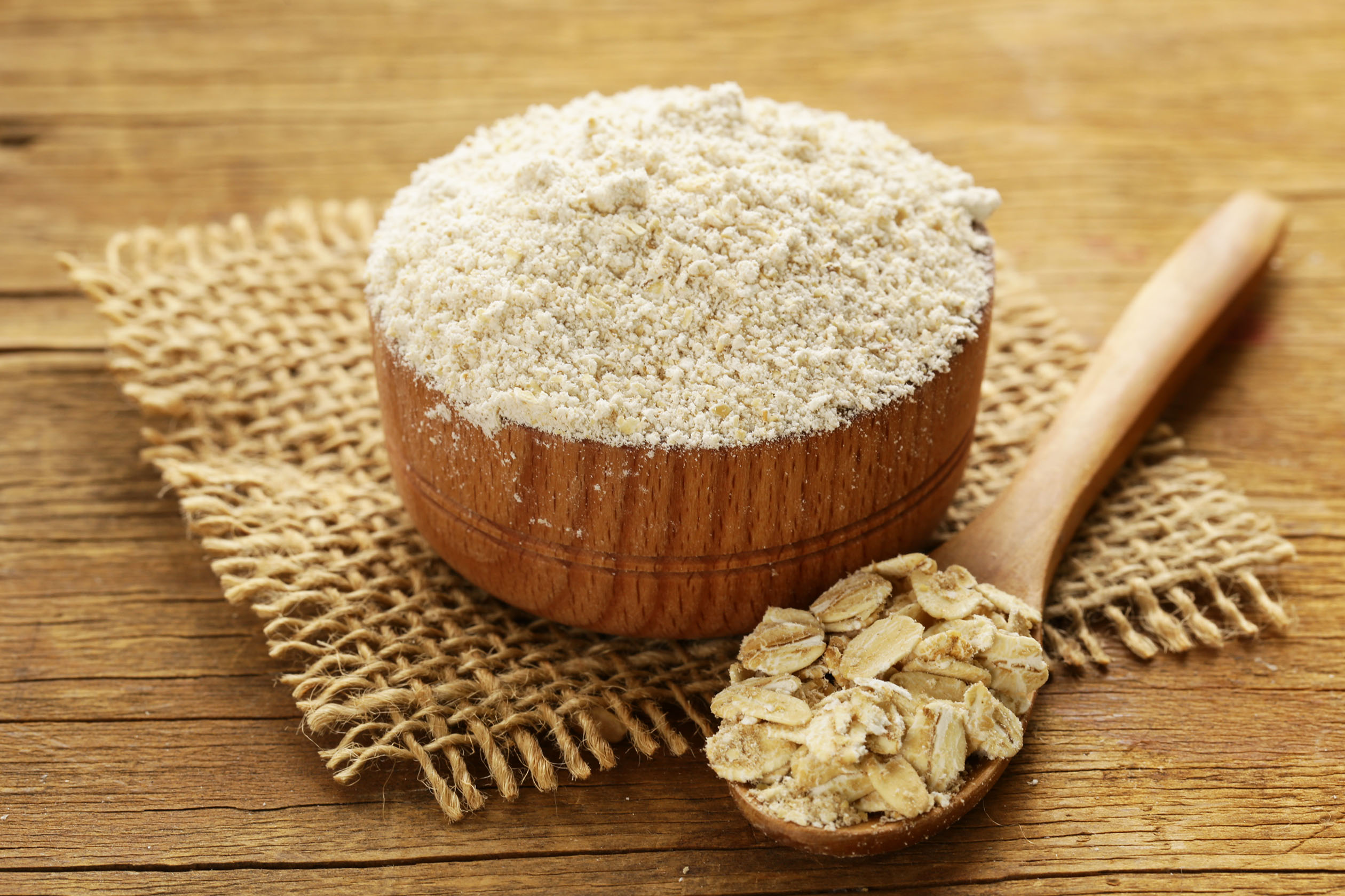 Bowl of oat flour next to oats