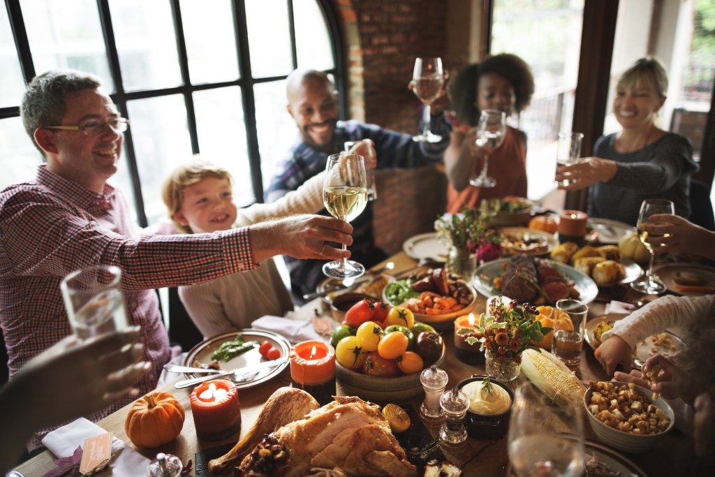 Family raising glasses at Thanksgiving table
