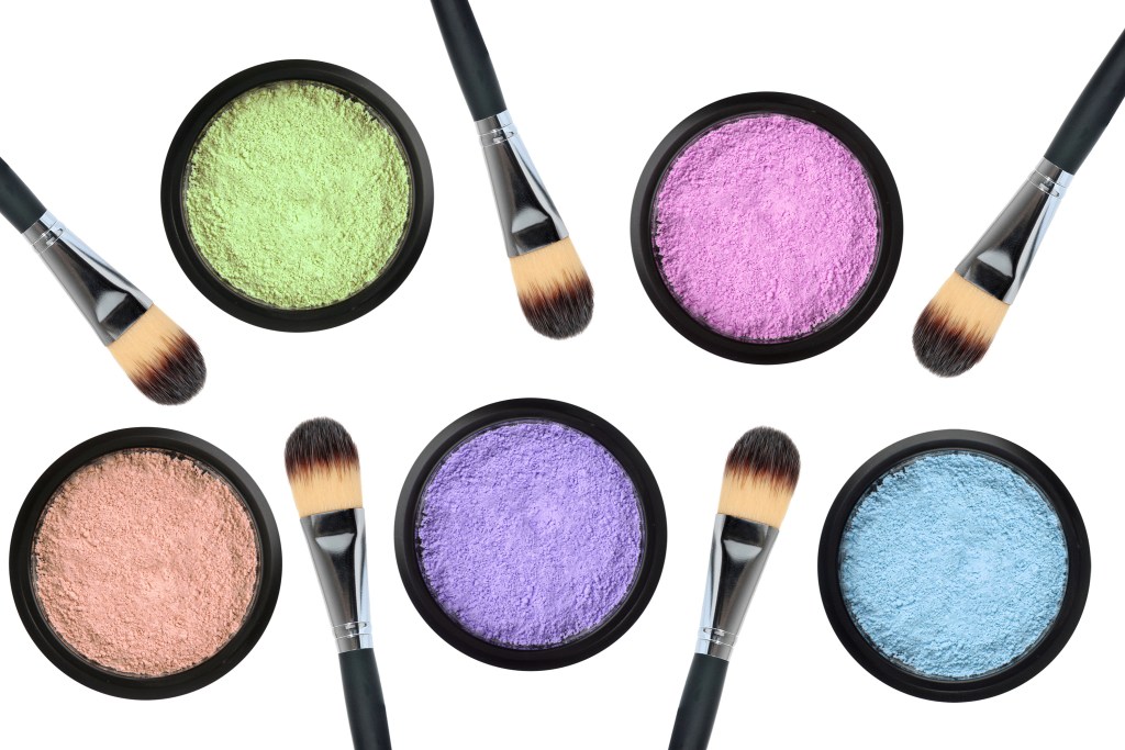 Grouping of pastel-colored eyeshadows with brushes