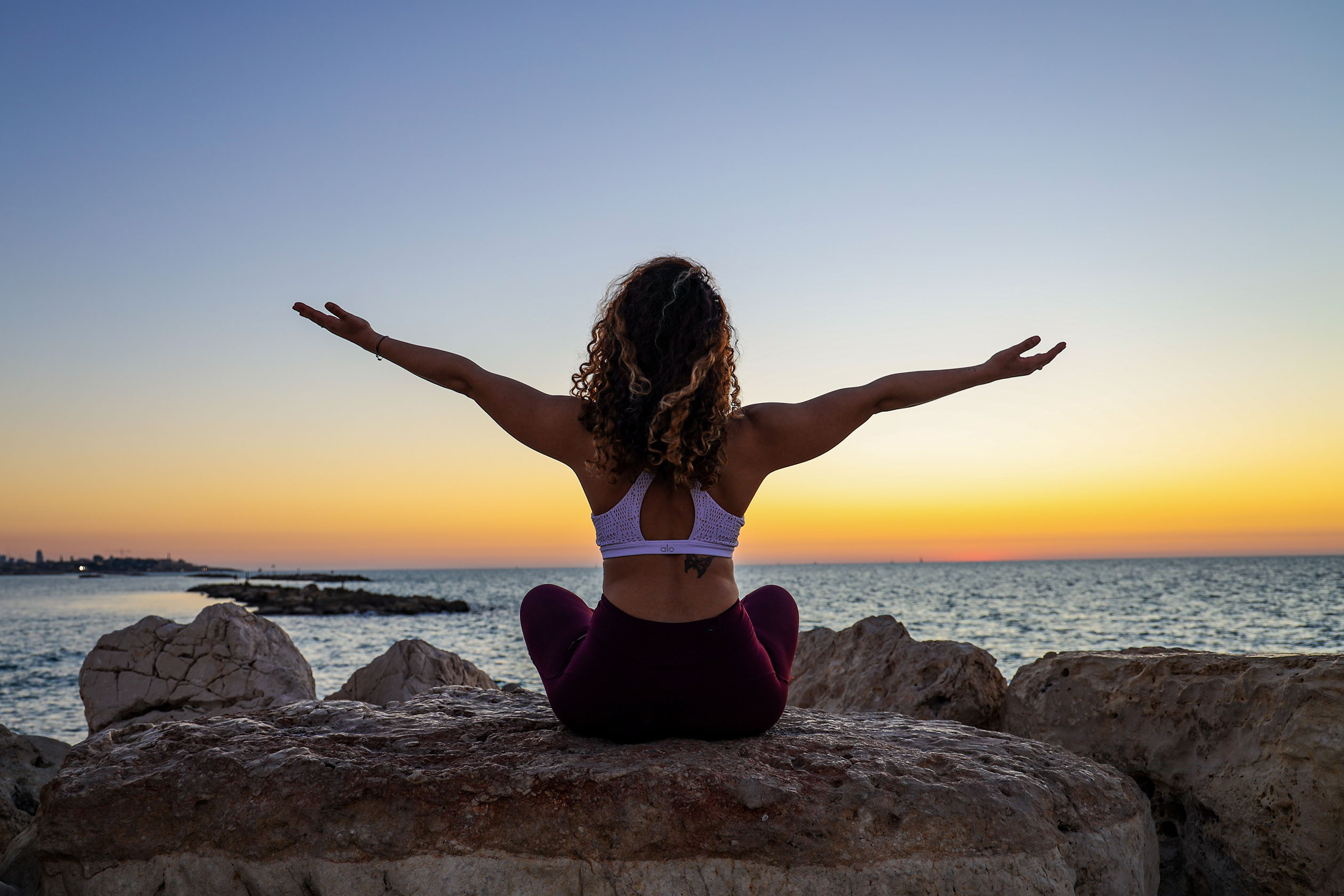 Relaxed woman doing yoga by the ocean