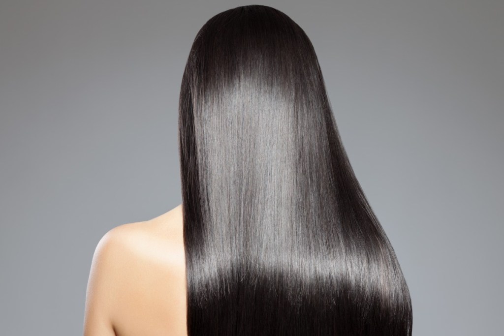 the back of a person's head. she has long, shiny, straight hair