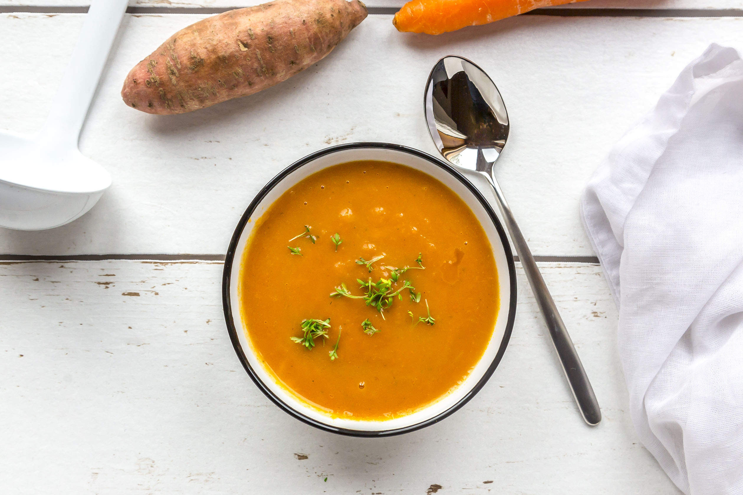 Sweet potato soup with ladle and ingredients
