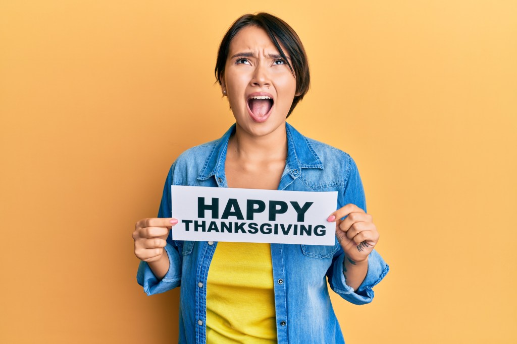 Woman screaming holding 'Happy Thanksgiving' sign