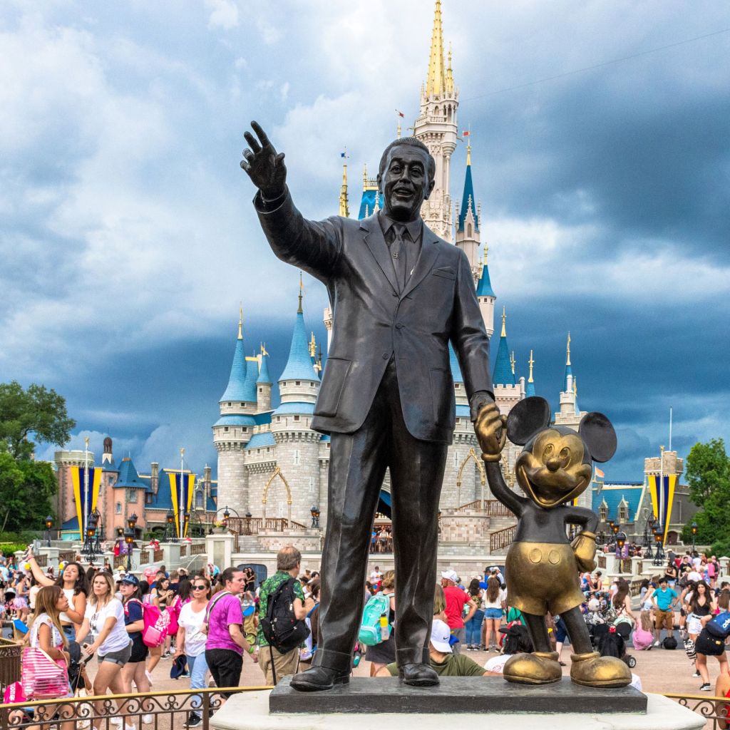 Iconic Walt Disney and Mickey Mouse statue in front of Cinderella Castle