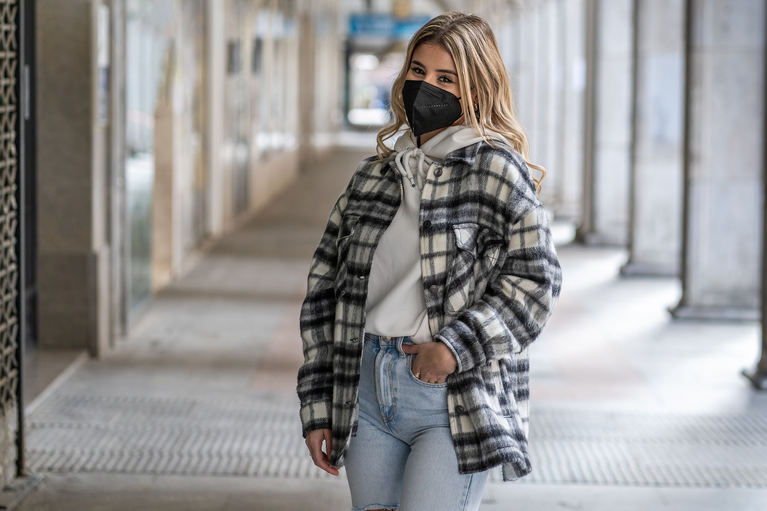 Woman wearing a plaid shacket and jeans