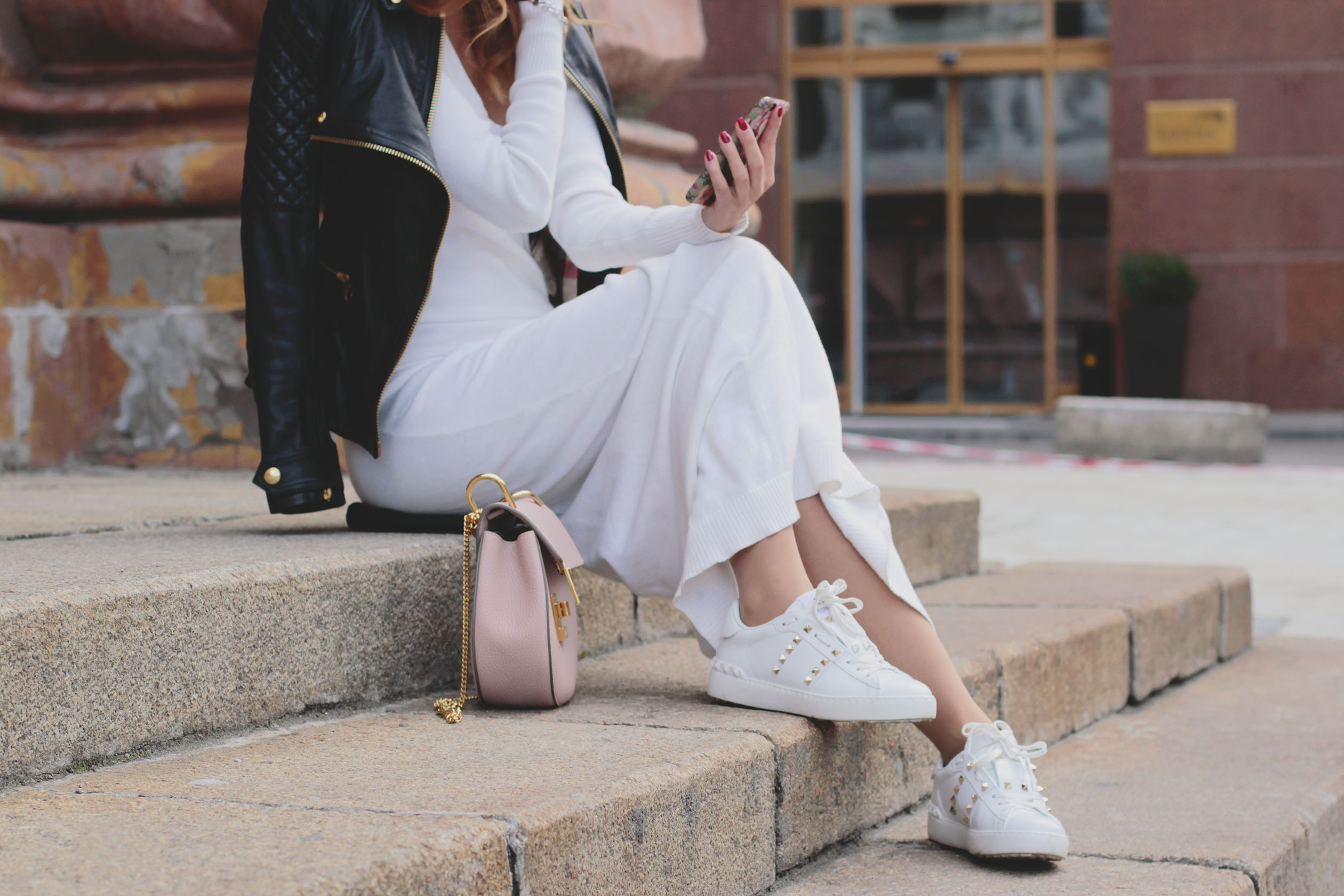 Woman wearing a white knit dress and sneakers